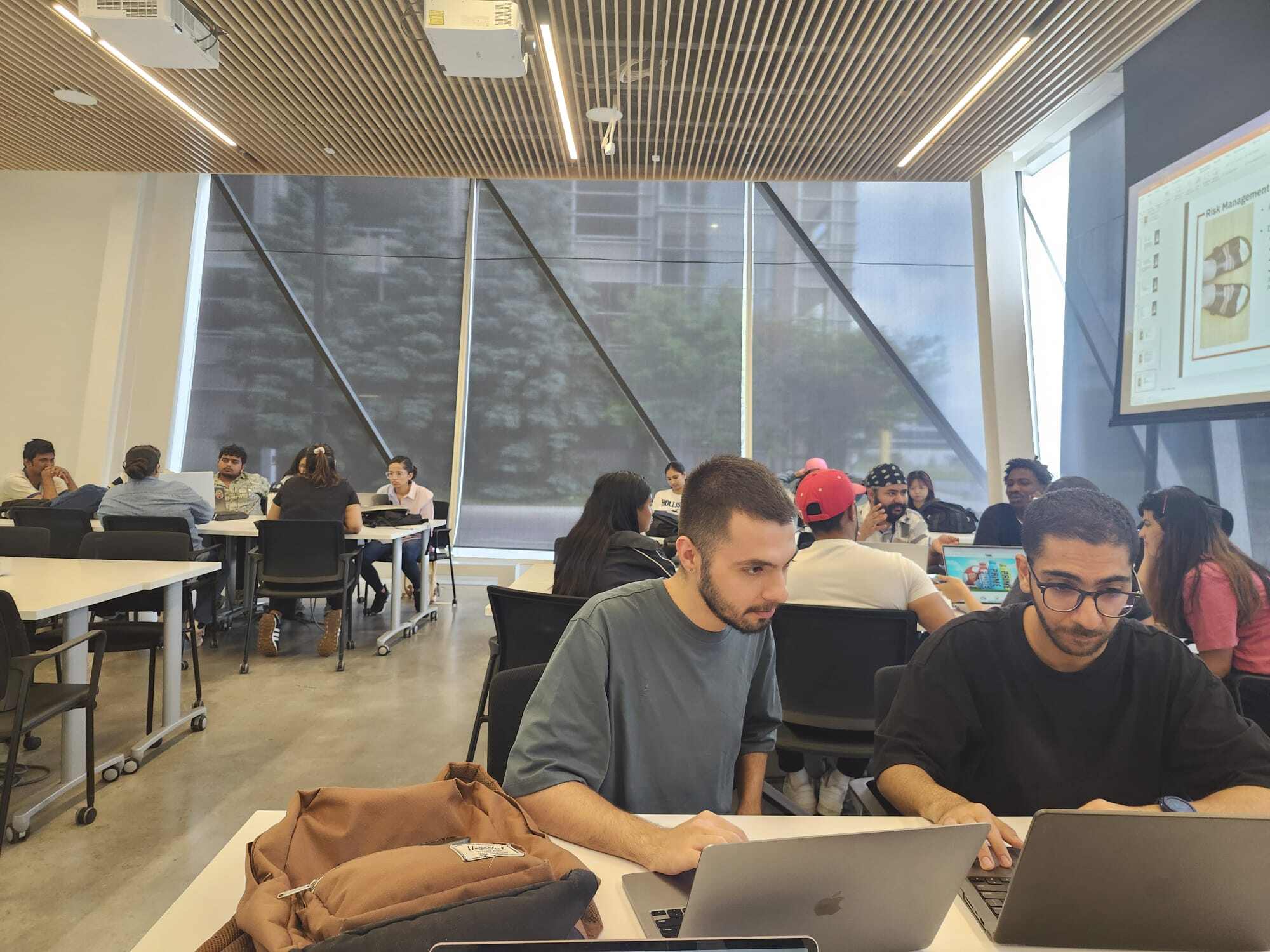 Students looking at their laptop sitting in the class.