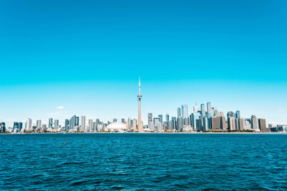 CN tower and building surrounding it from across the lake ontario
