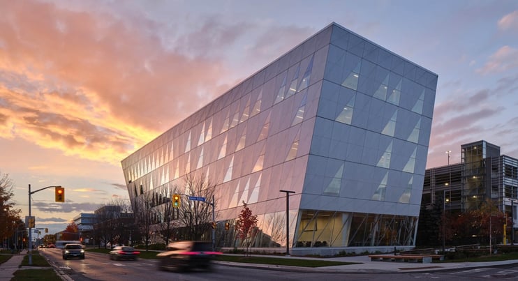 ork University School of Continuing Studies building in the evening with cars on the road and trees around the building.