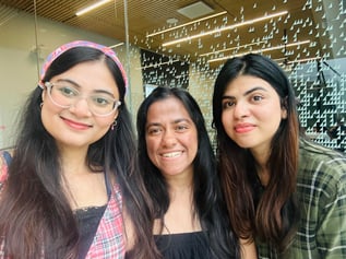Three girls posing together, smiling in front of York University SCS, showcasing their camaraderie and the vibrant campus atmosphere.