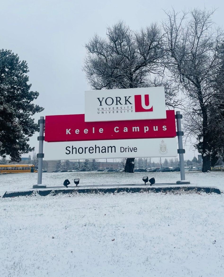 A group of 4 girls posing for a picture behidn the white table which says,'York University school of continuing studies